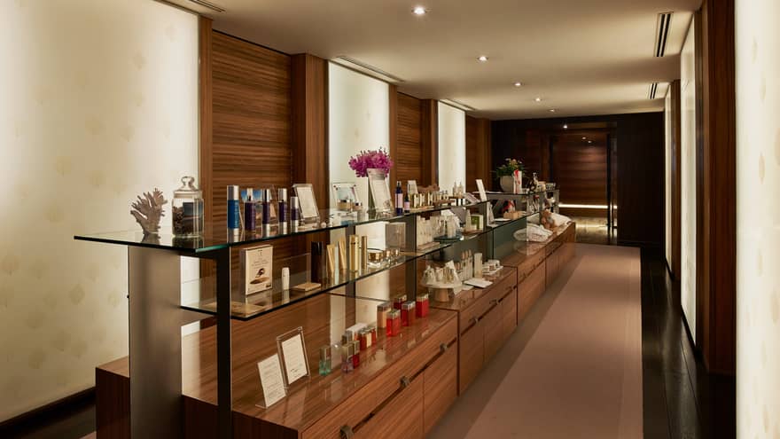 Wood and glass display shelves with boutique items in dimly lit hallway