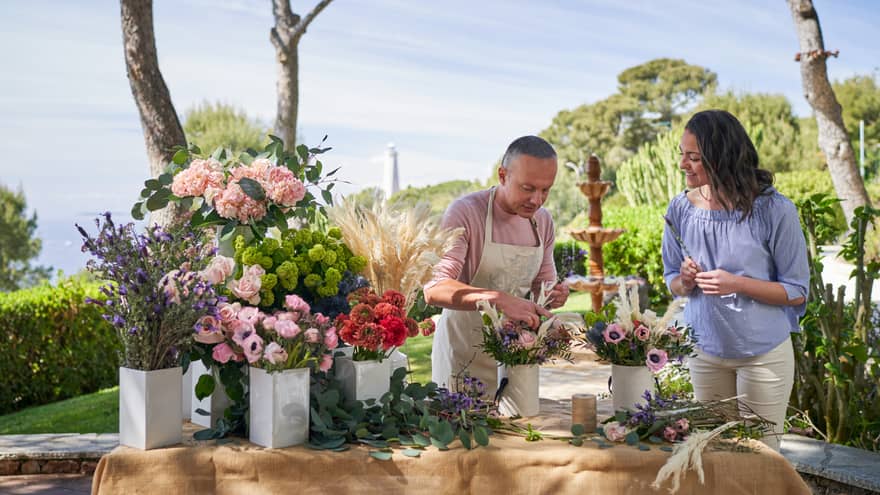 Florist wearing apron teaching guest the art of flower arranging