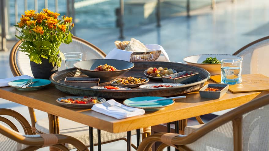 Large round platter with vegetable dishes, salads on patio table