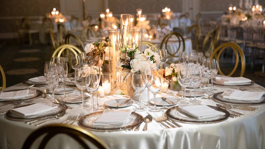 Round wedding banquet dining table with white flowers, glowing candles