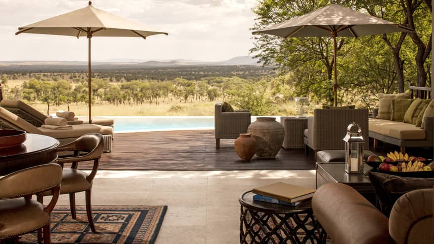 Two-bedroom villa patio with multiple seating areas, decorative clay pots, pool