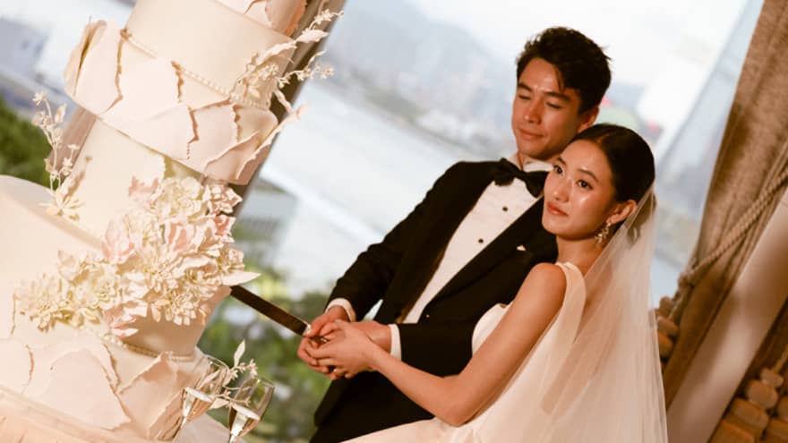 Bride and groom cut large wedding cake