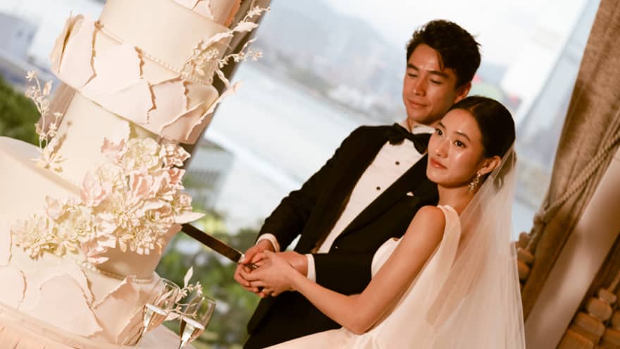 Bride and groom cut large wedding cake