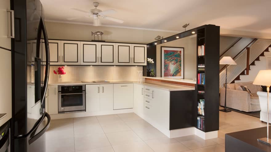 Residence Villa kitchen with black-and-white cupboards, shelves, white tile floors