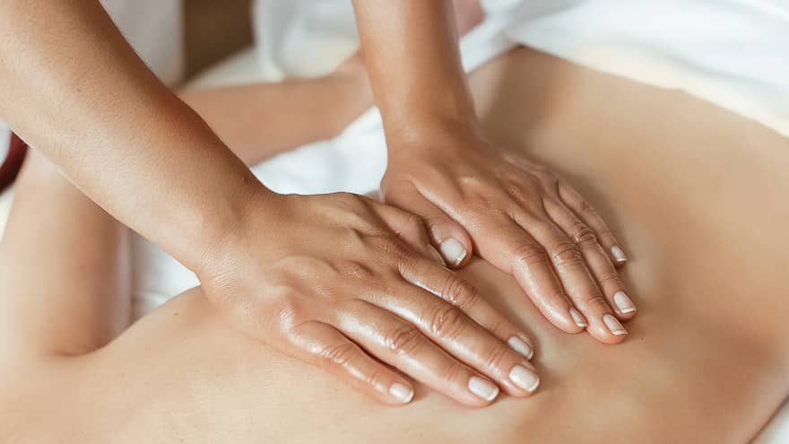 Hands performing a back massage