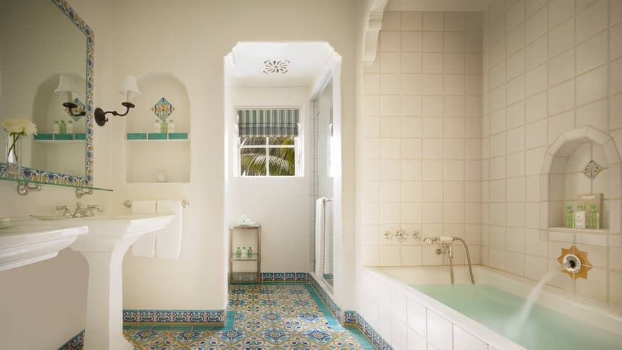 White tile bathroom, long tub, colourful Spanish Colonial-style tiles