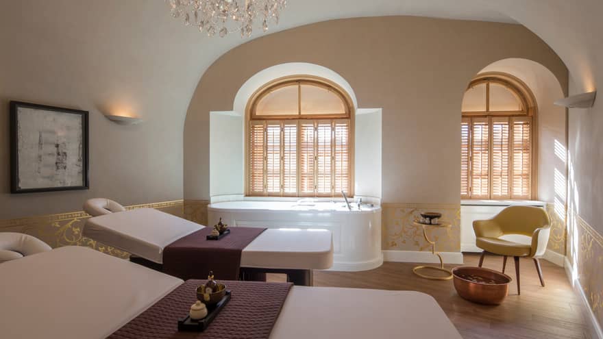 Vltava spa couples massage room with beds side-by-side, spa tub in front of window