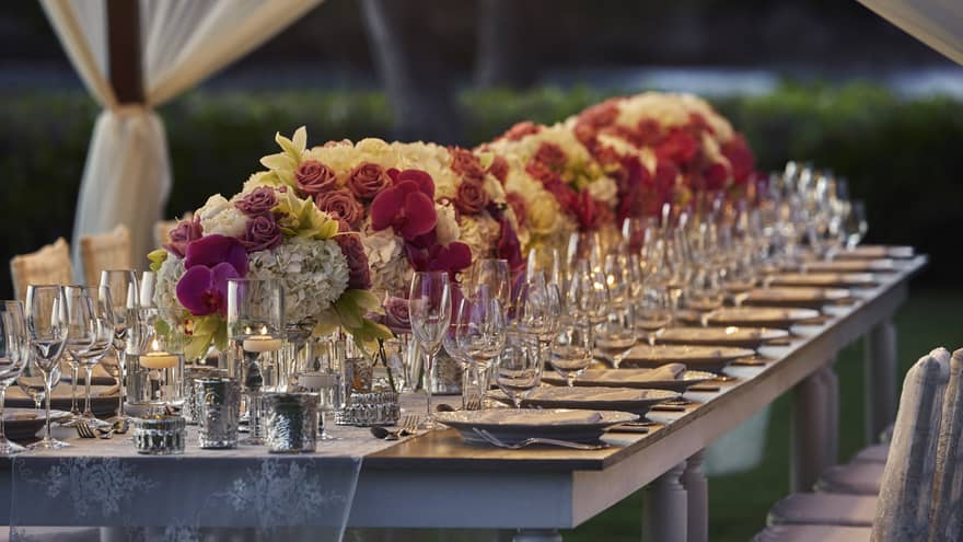 A beautifully set wedding dining table decorated with white and pink flowers, creating a serene and inviting atmosphere