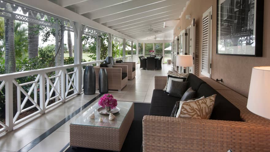 Residence Villa wicker patio sofa, table under covered porch with white trim