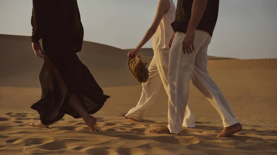 Three people walking in the dessert