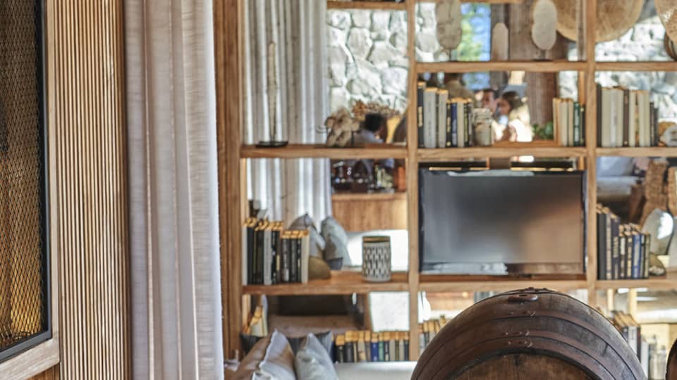 A bartender smiles as four guests sample different kinds of rum at a table set with bowls of chocolate, glasses and bottles.