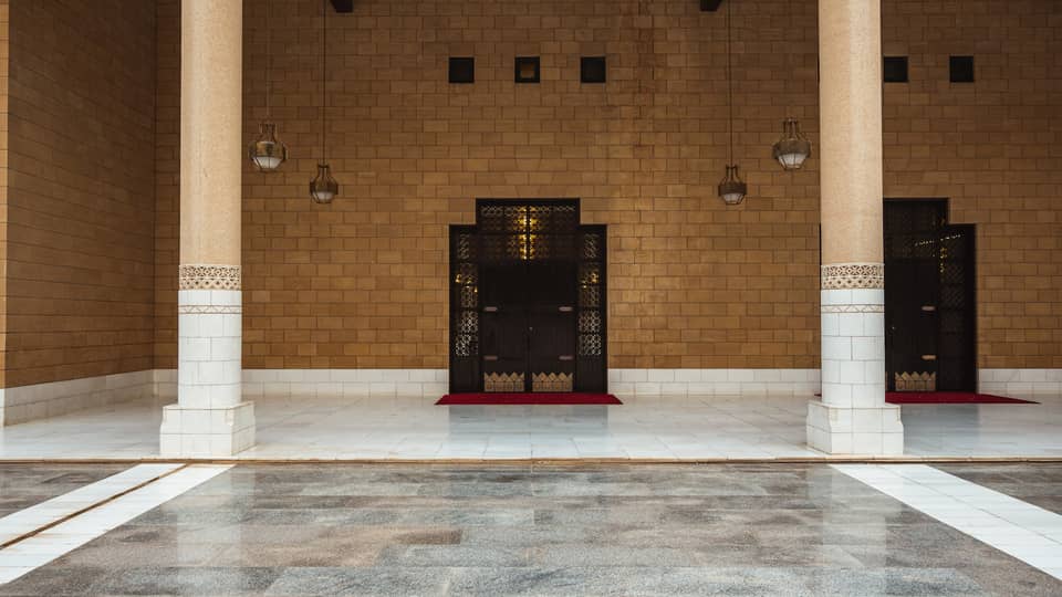 A brown stone wall with grey tile flooring.
