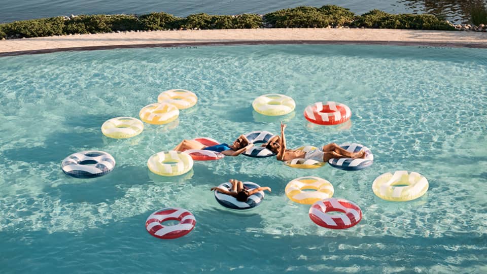 Guests floating on floats in a pool.
