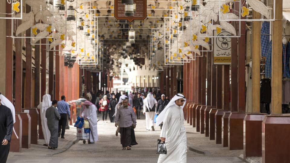 Shoppers walking through Souk al Mubarakiya