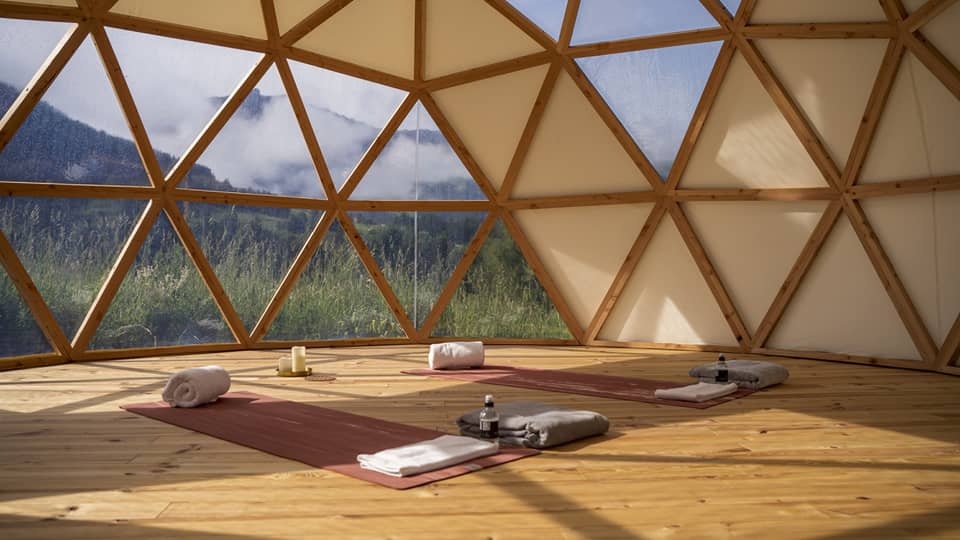 Spa studio set with two yoga mats and mountain view outside hive-like windows