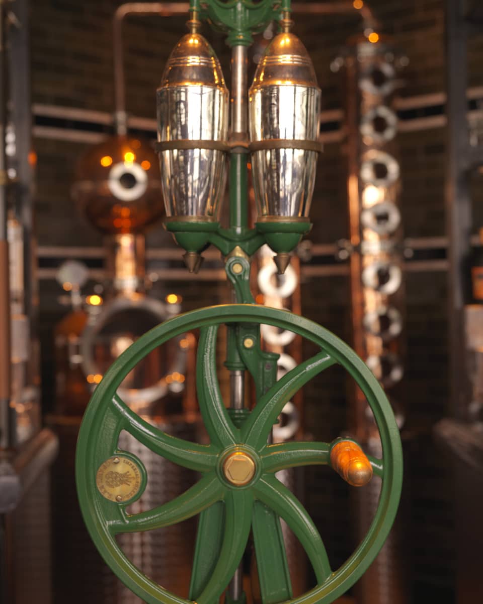 Close-up of copper, silver and green rare 5-foot-tall, hand-operated cocktail shaker at Butcher & Still