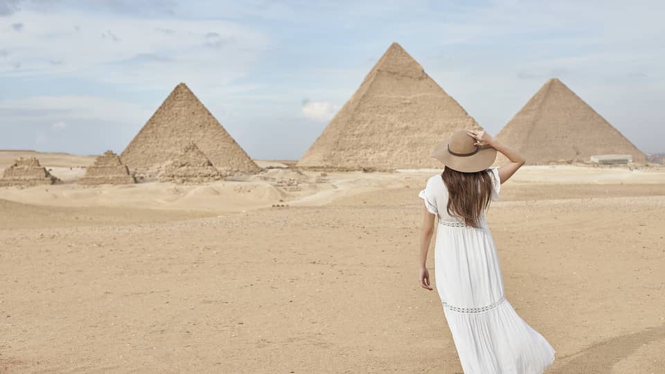 A guest wearing a linen dress observing the Great Pyramids