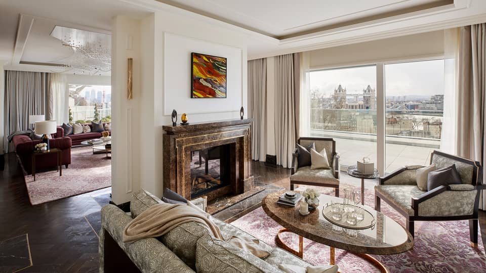 Elegant residence living room with fireplace and tall windows with river views