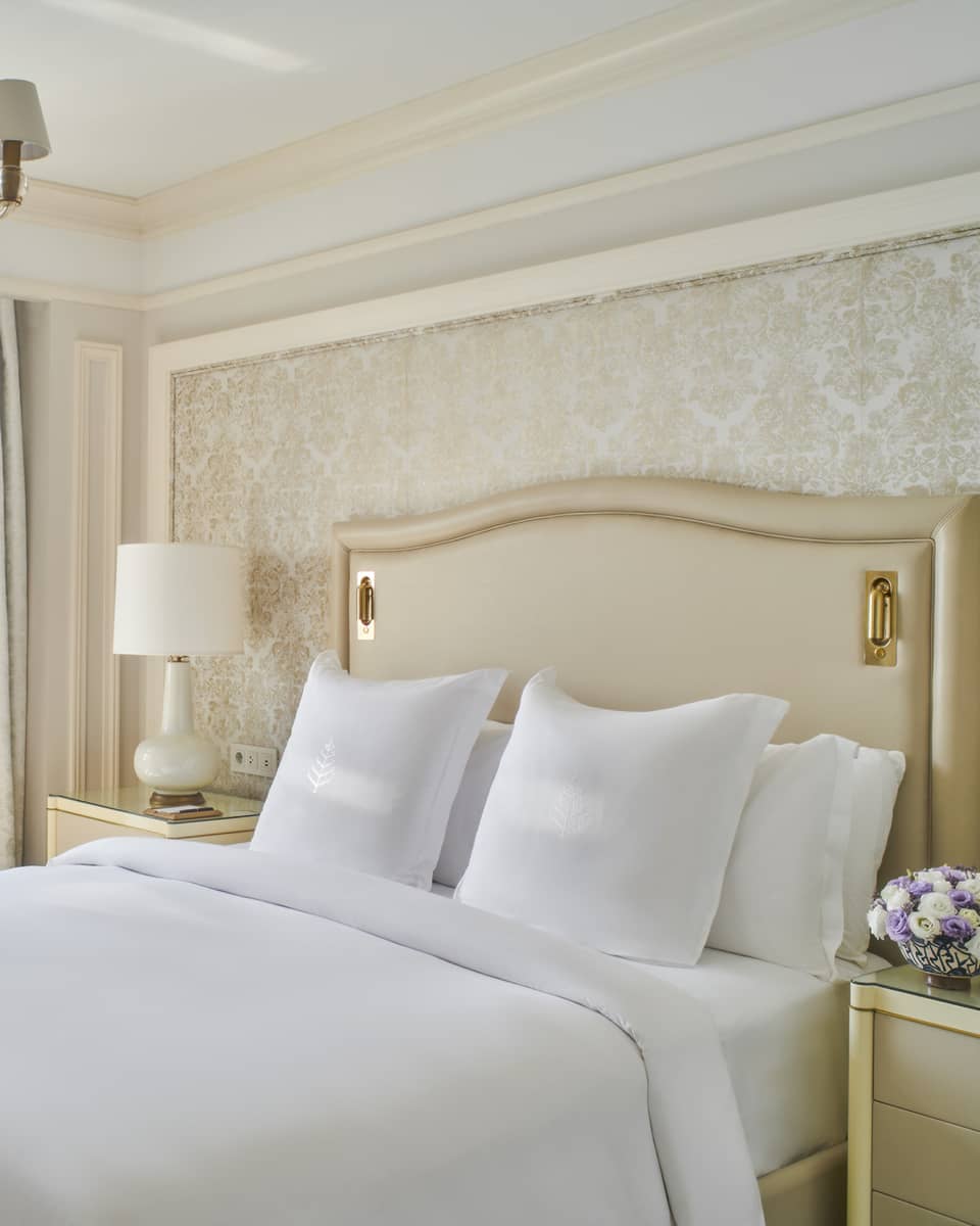Guest bedroom with king bed, white linens and cream tufted headboard; floor-to-ceiling window with views of the River Nile