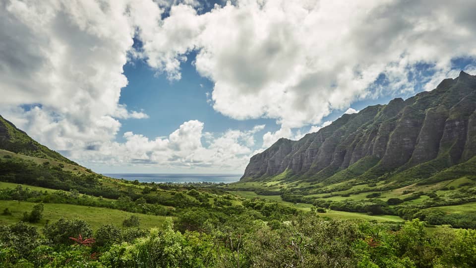 Oahu sweeping green cliffs, mountains, under blue skies