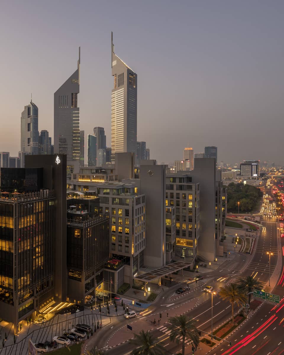 Aerial view of Dubai city skyline, road, lights around Four Seasons International Financial Centre hotel at sunset