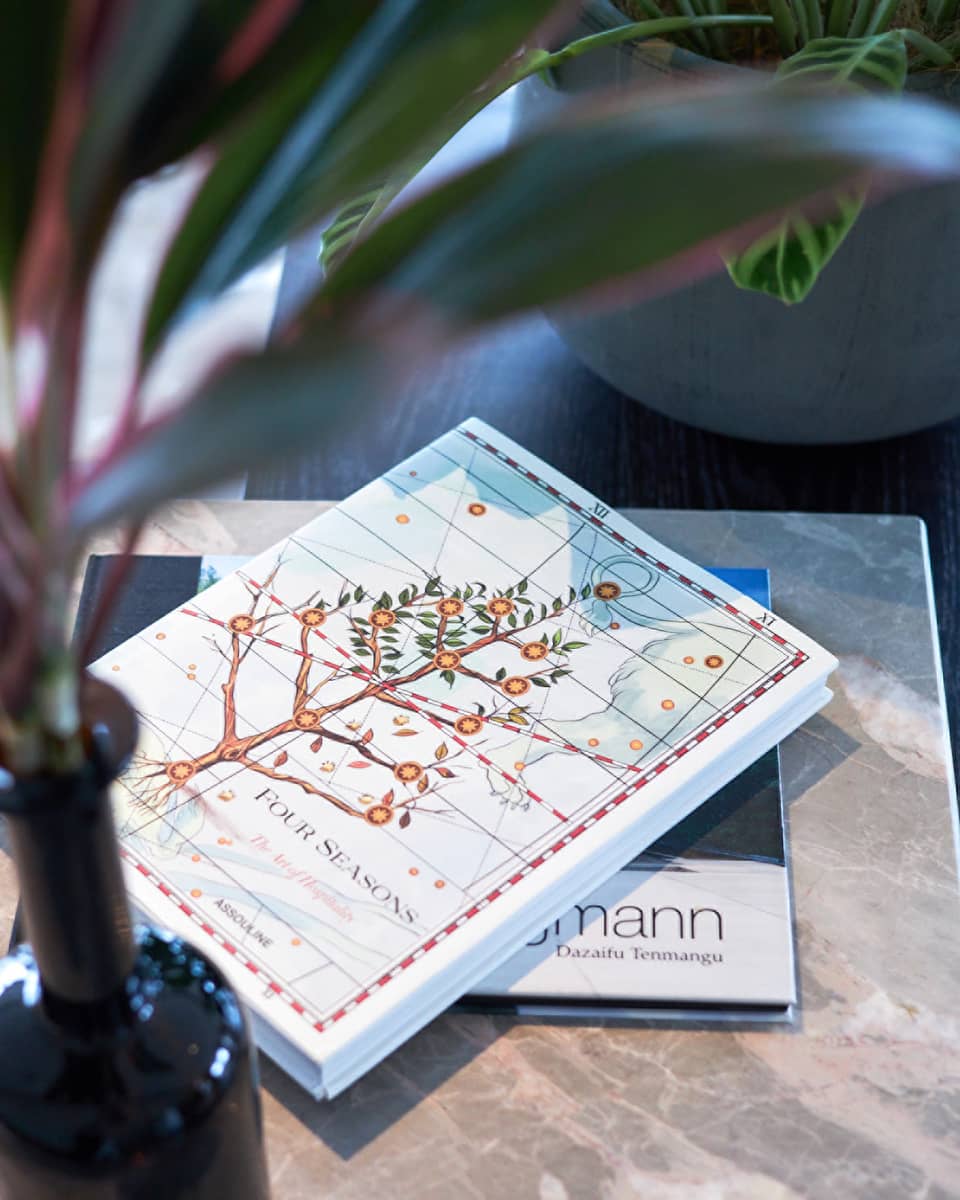 Four Seasons hotel book with an illustrated cover featuring a flowering tree on a table