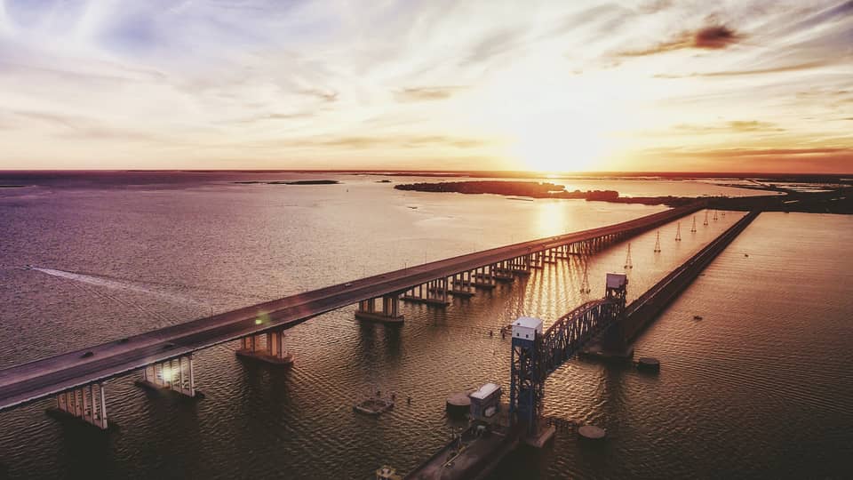 The sun sets over a long bridge in Houston