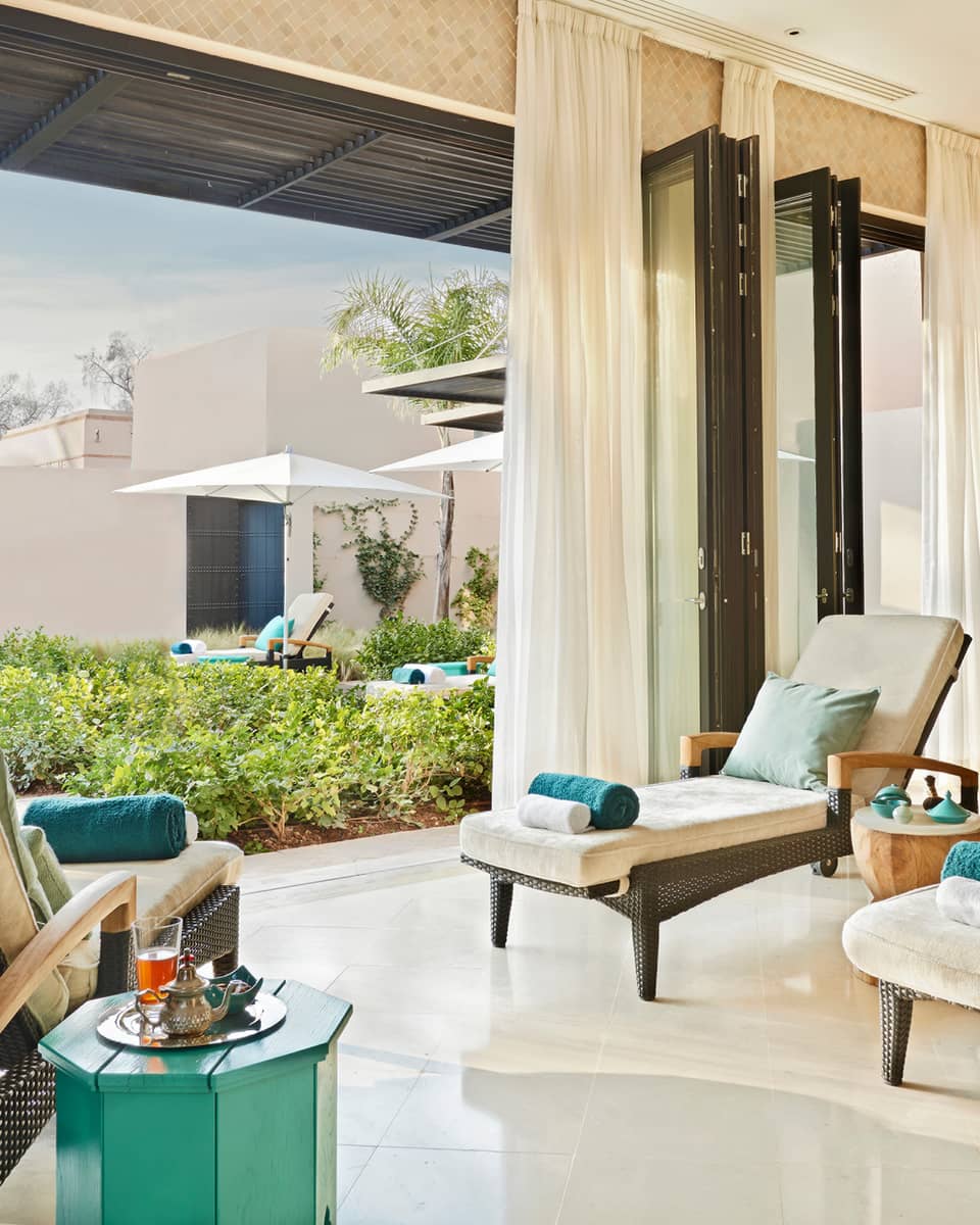 Lounge chairs with rolled towels in large open-air sunny spa patio
