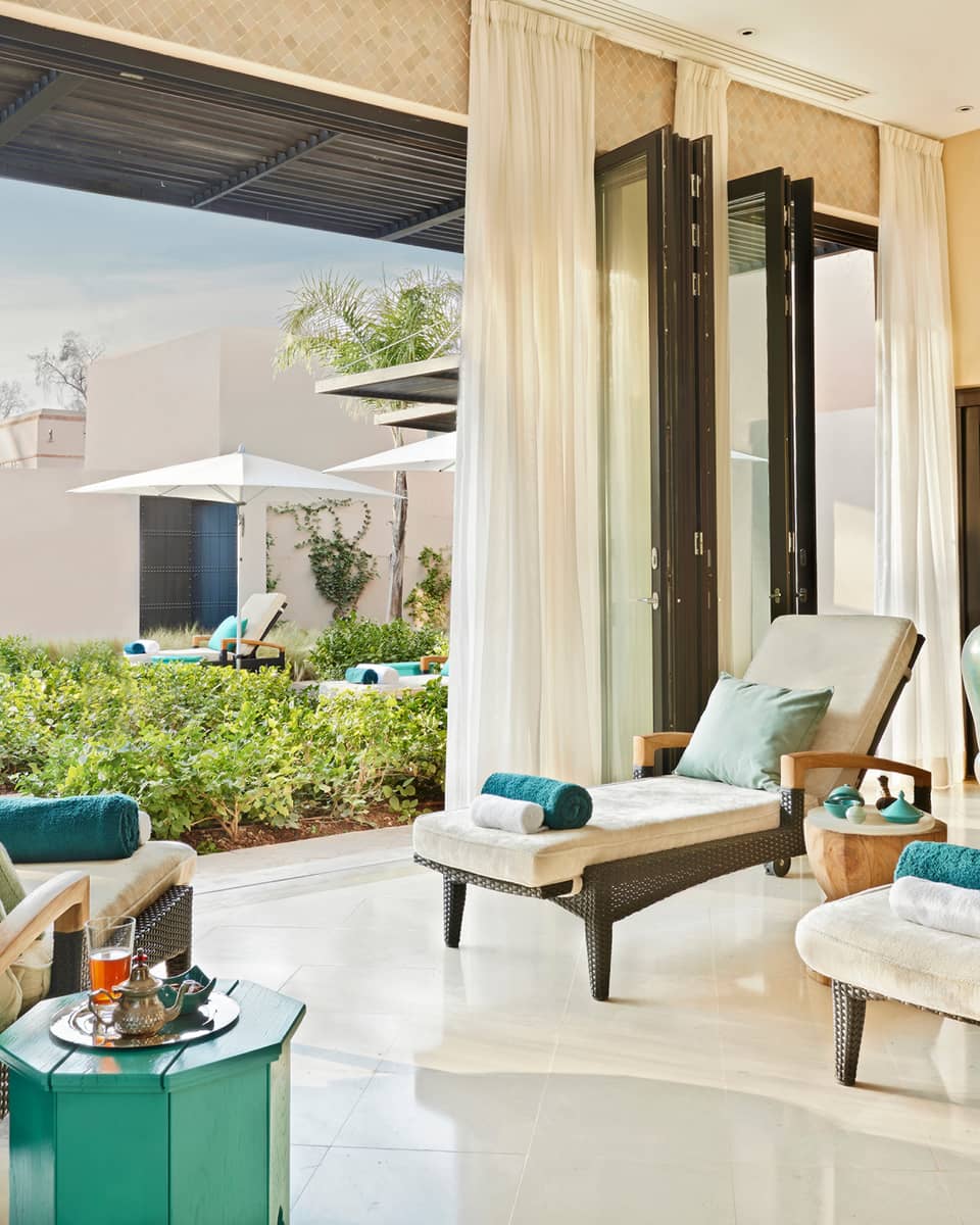 Lounge chairs with rolled towels in large open-air sunny spa patio