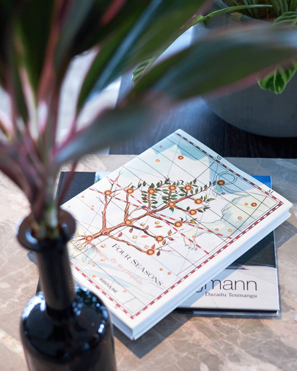 Four Seasons hotel book with an illustrated cover featuring a flowering tree on a table