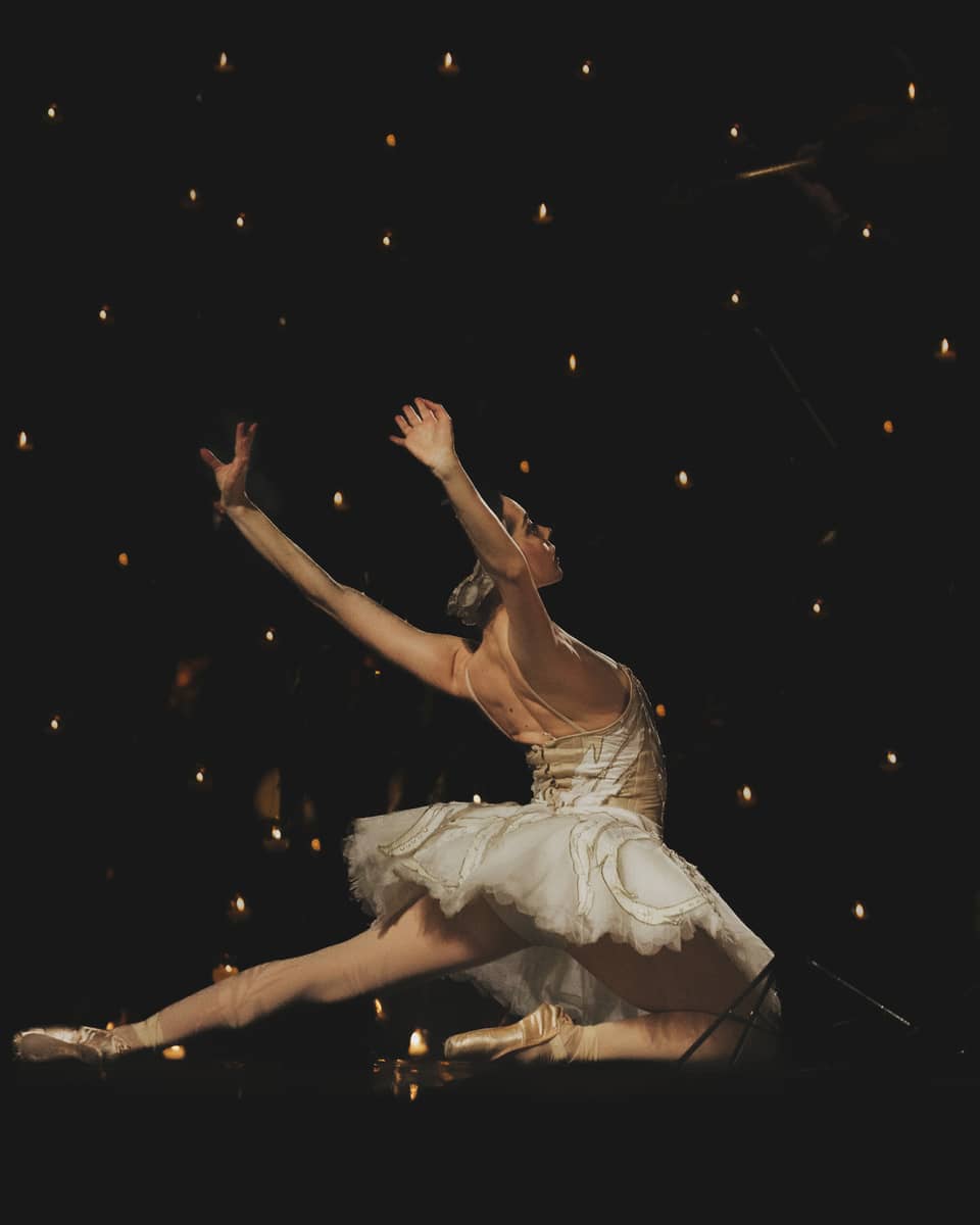 A ballerina dancing in front of a dark background