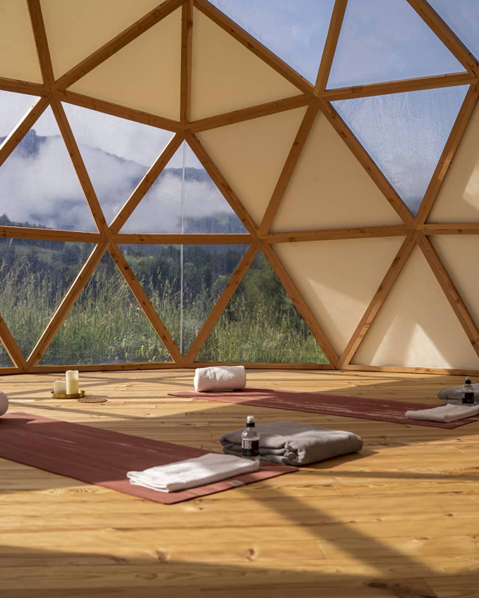 Spa studio set with two yoga mats and mountain view outside hive-like windows