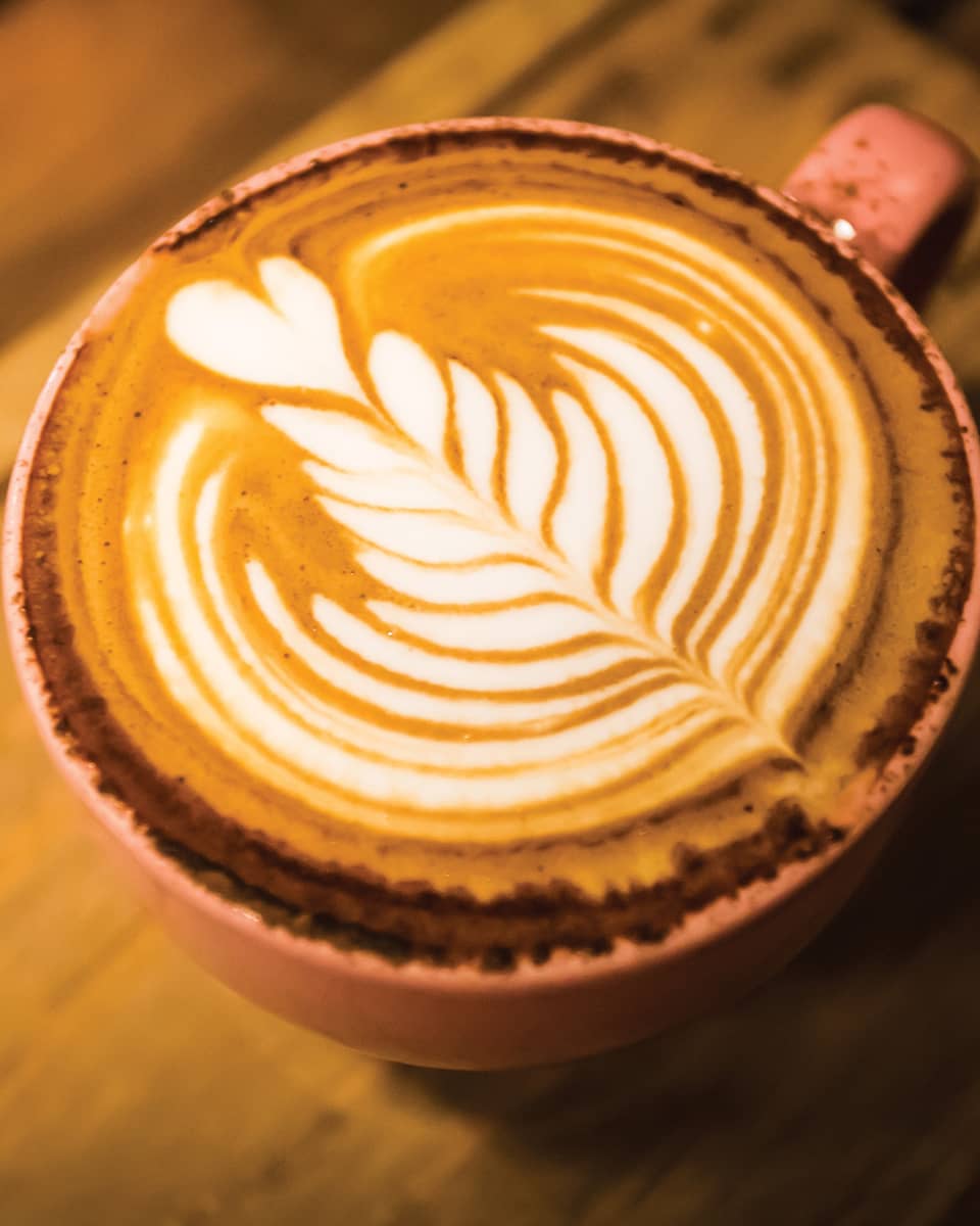 Close-up of latte coffee with flower design in foam
