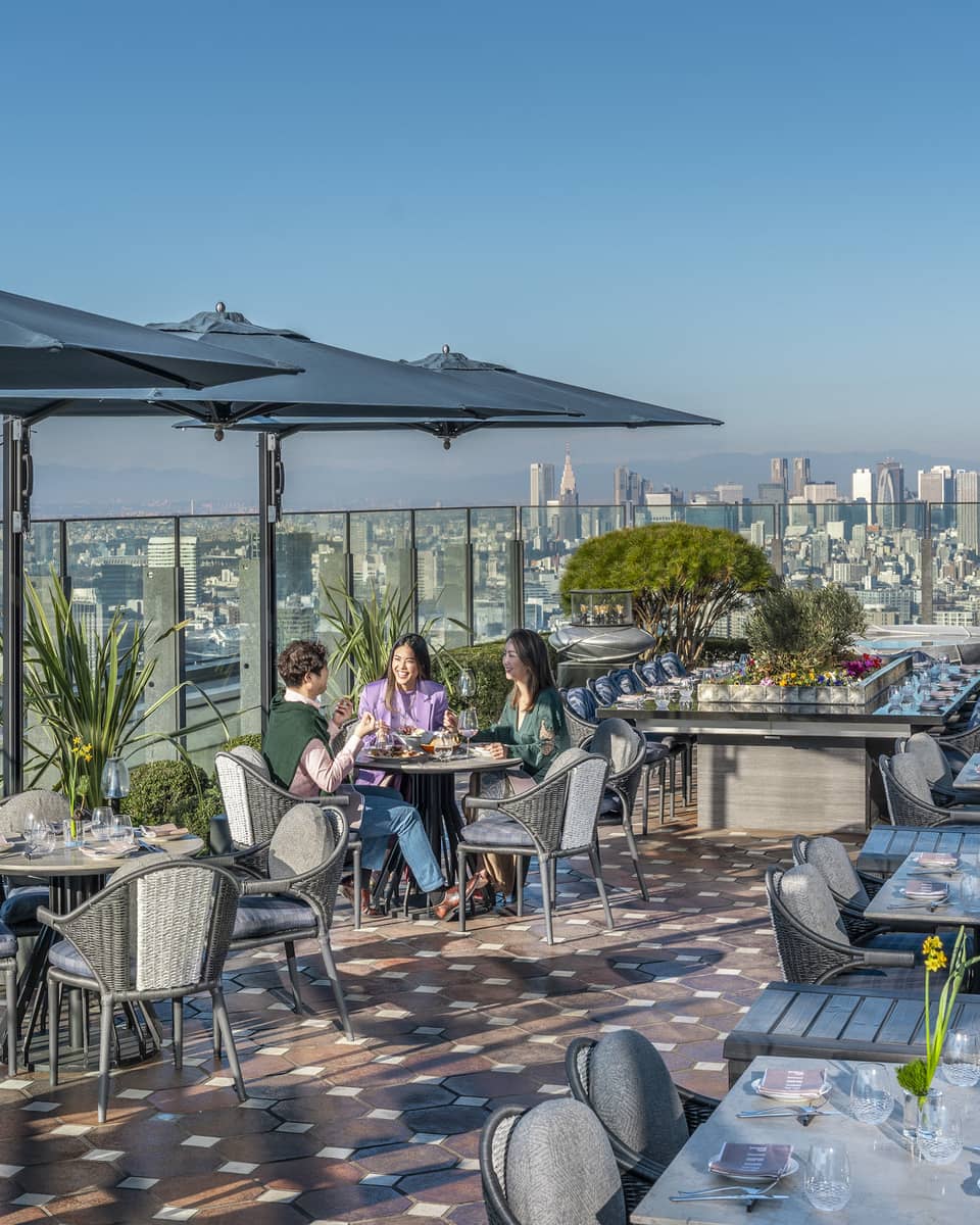 Group of three friends enjoy a meal on PIGNETO's open-air terrace