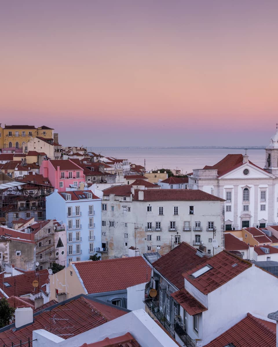 Aerial view of Lisbon traditional buildings with white houses, apartment buildings with brown roofs, white church
