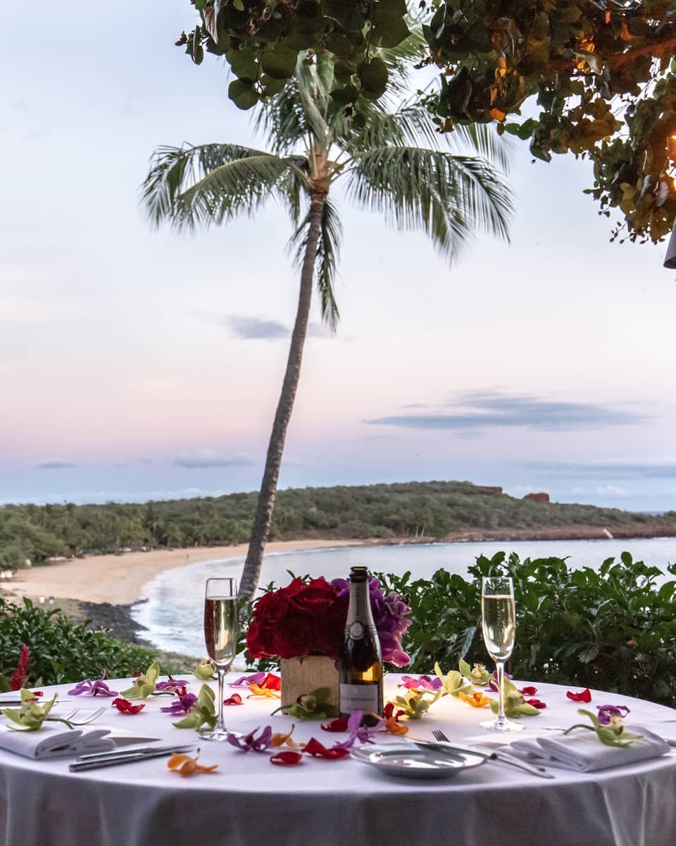Round dining table set for two outside overlooking tropical bay
